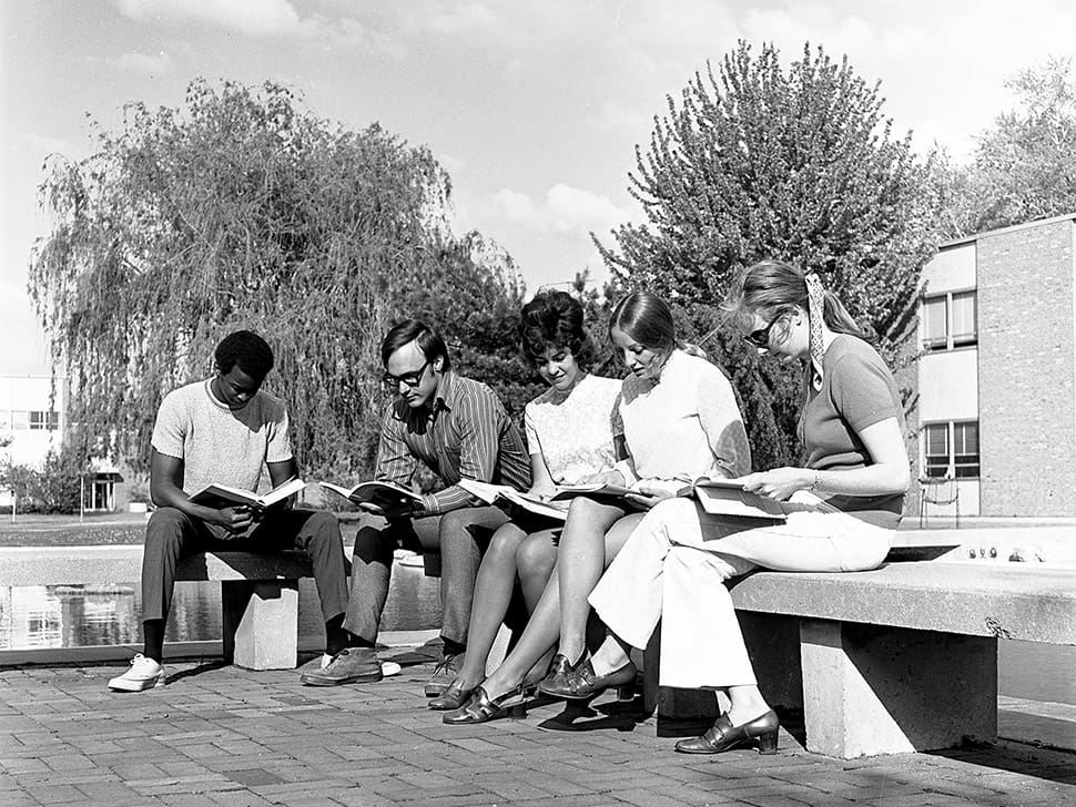 Students sitting outside on the University of Michigan-Dearborn campus.