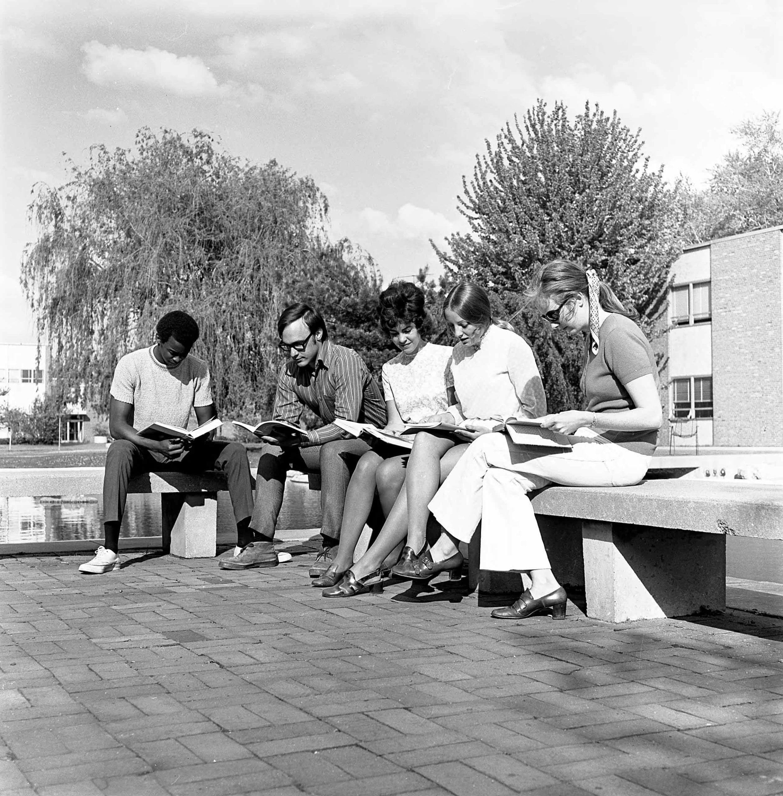 Students sitting outside on the University of Michigan-Dearborn campus.