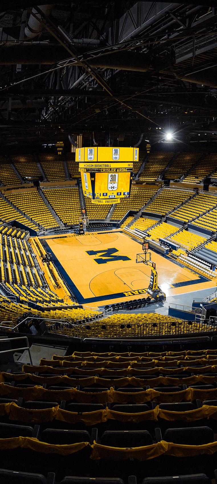 Maize t-shirts are draped over the seats of an empty Crisler Center.