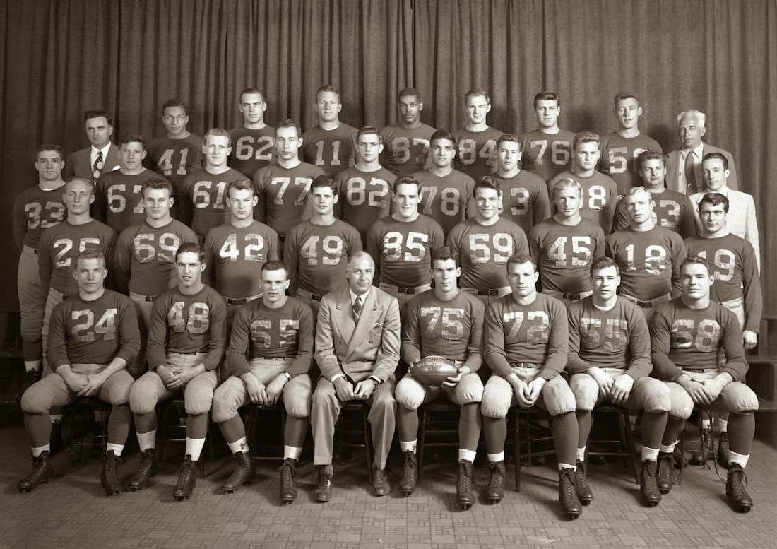 Group photo of the University of Michigan 1947 football team with their coaches.