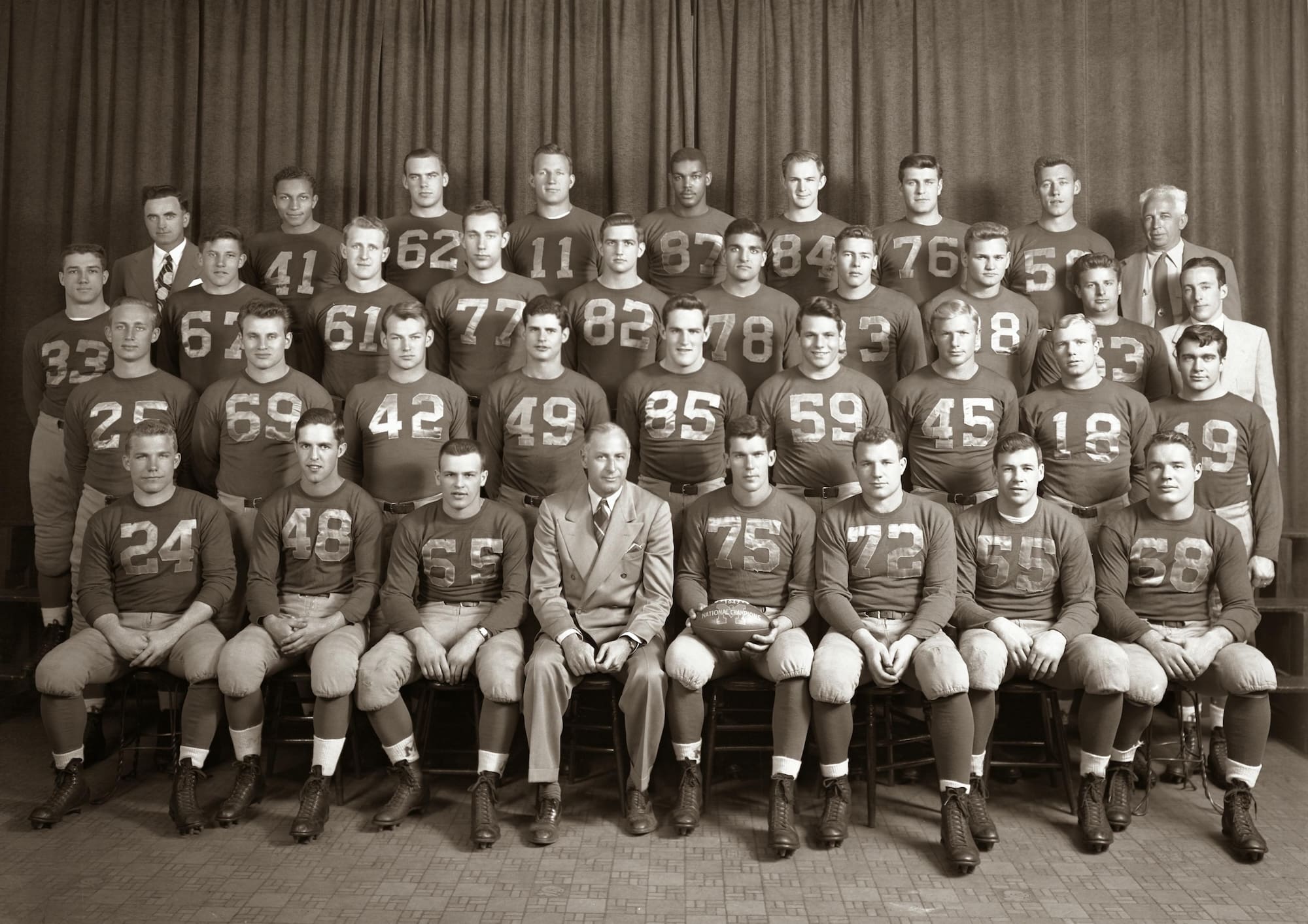 Group photo of the University of Michigan 1947 football team with their coaches.