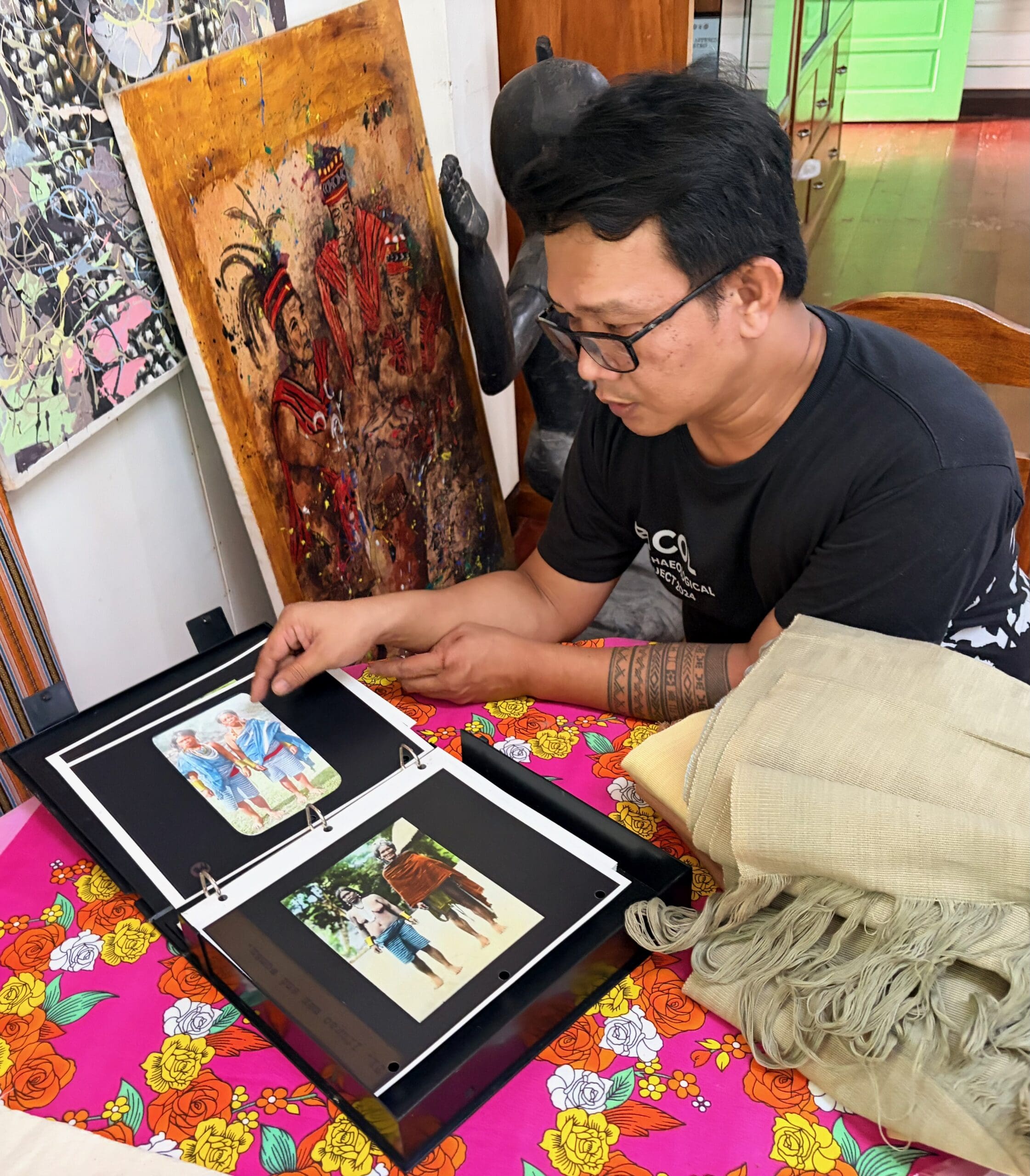 Marlon Martin sitting and looking at a binder of photos.