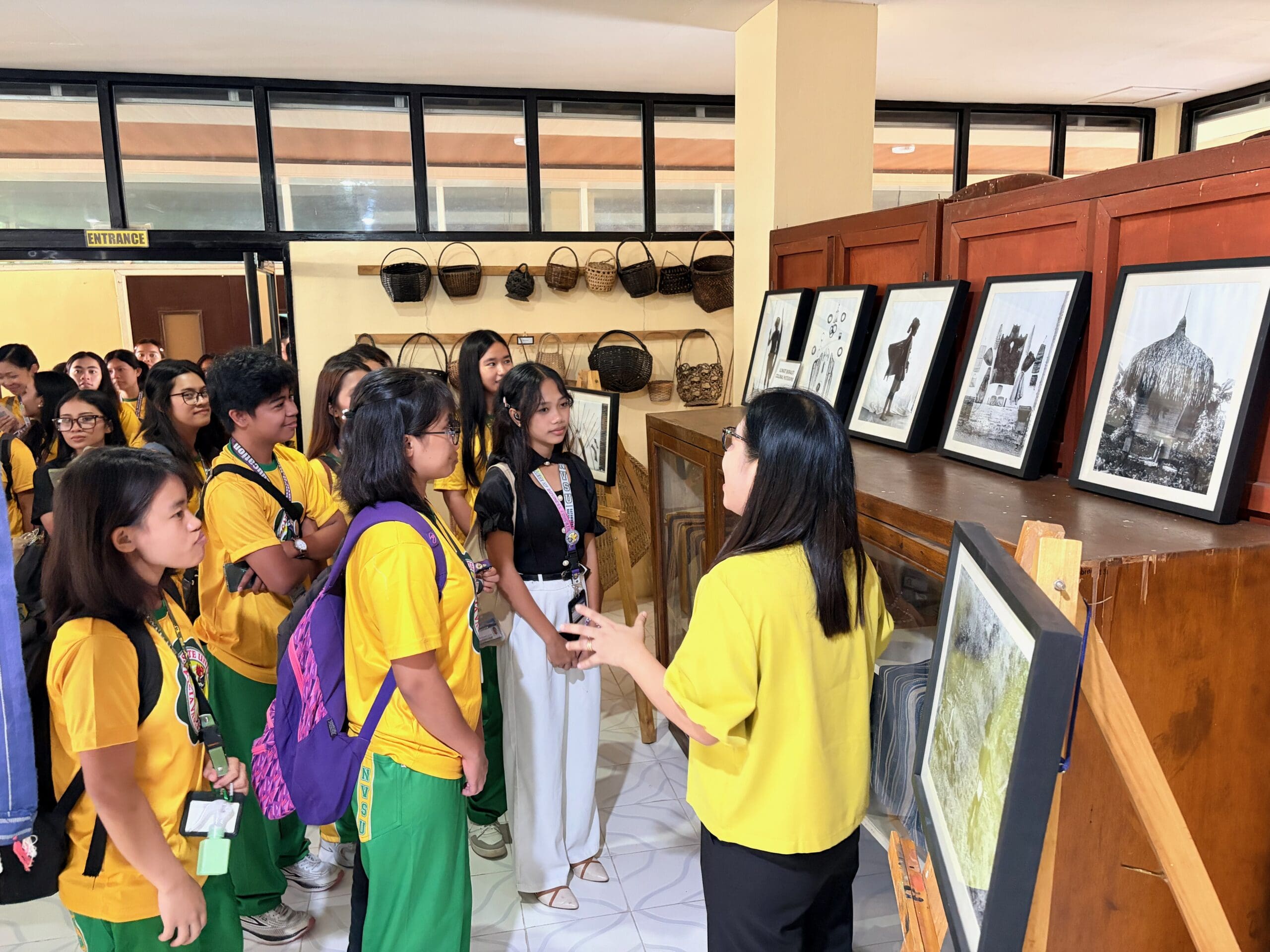 One person speaking to a group of undergraduate students about displayed historical photos.