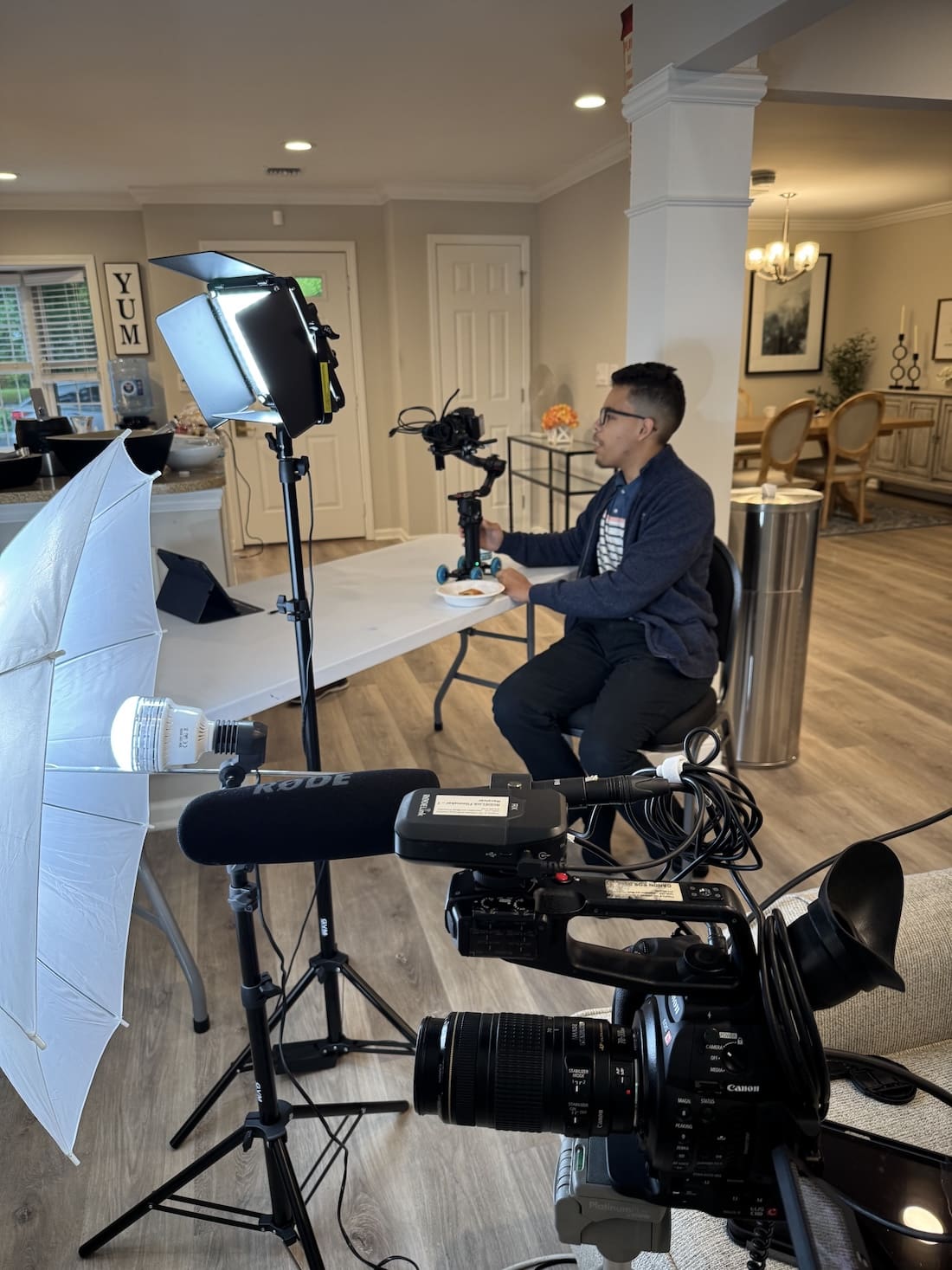 Man sits behind camera as he films an interview in progress.