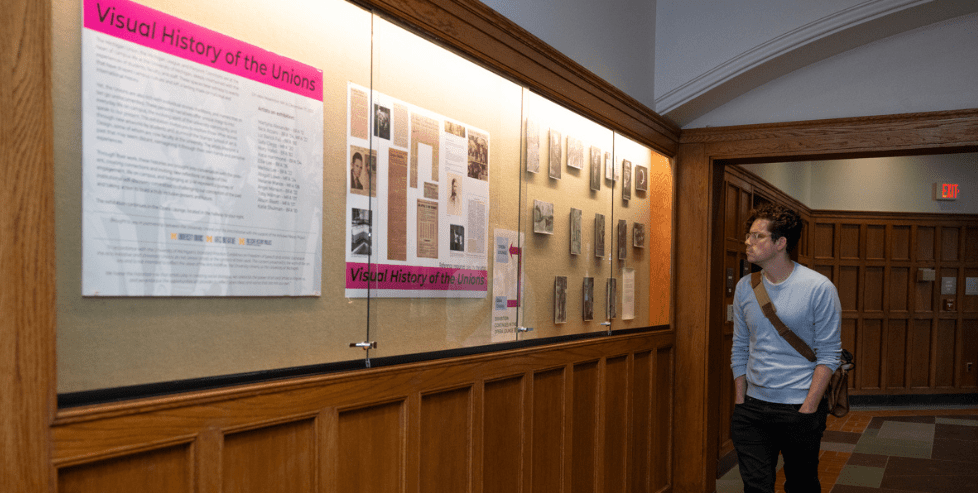 A visitor views the Visual History of the Union exhibit at the Michigan Union.