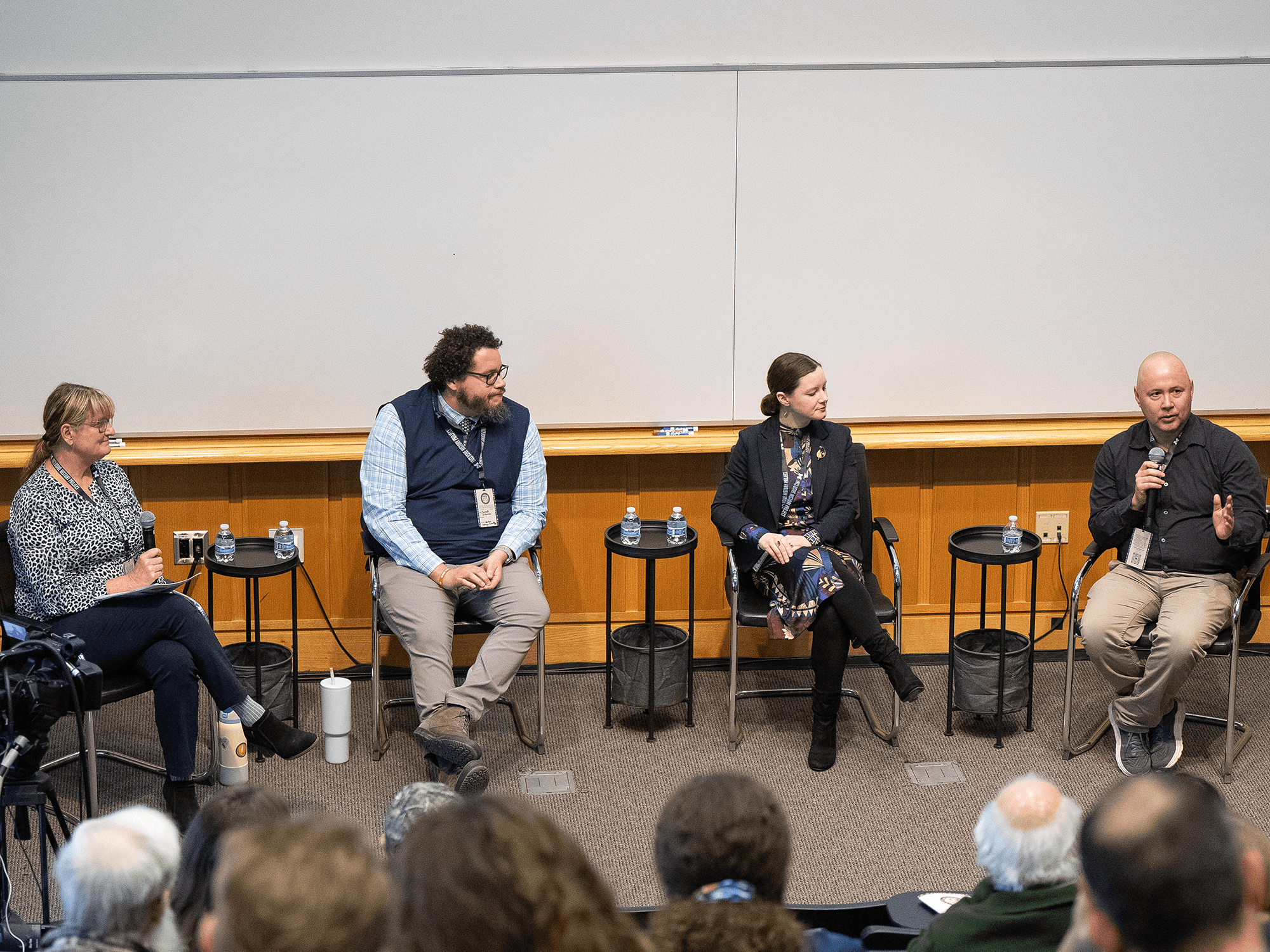 Seated on the stage, panelists listen to the moderator as he speaks into the mic, for the "Teaching Native American and Treaty History in K-12 Classrooms" panel.